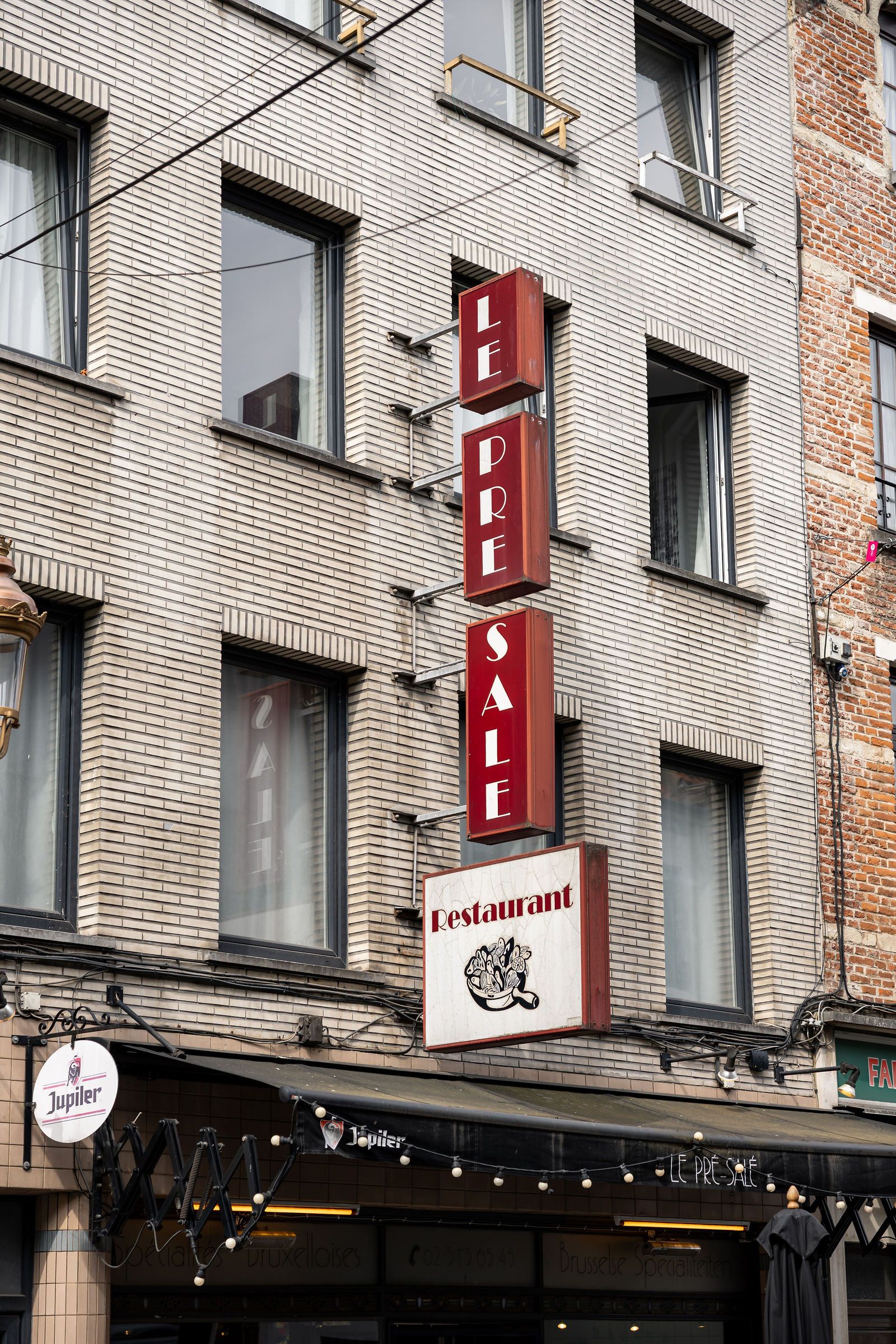 Enseigne verticale rouge « Le Pré Salé Restaurant » rue de Flandre à Bruxelles