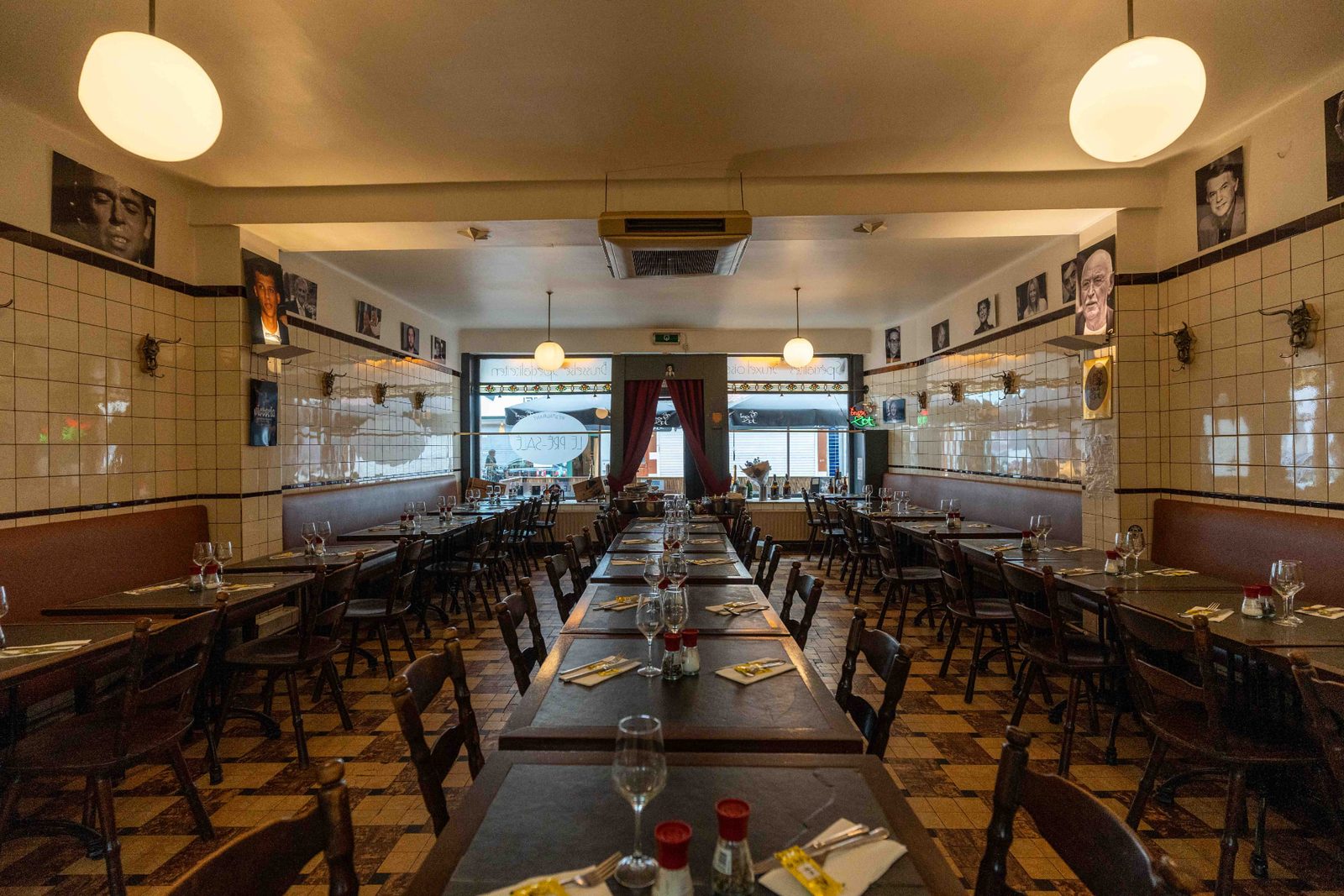Ambiance chaleureuse du Pré Salé sous les globes lumineux, longues tables prêtes pour le service des moules