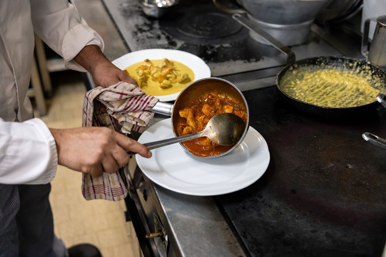 Sauce tomate nappée à la louche sur une assiette au passe