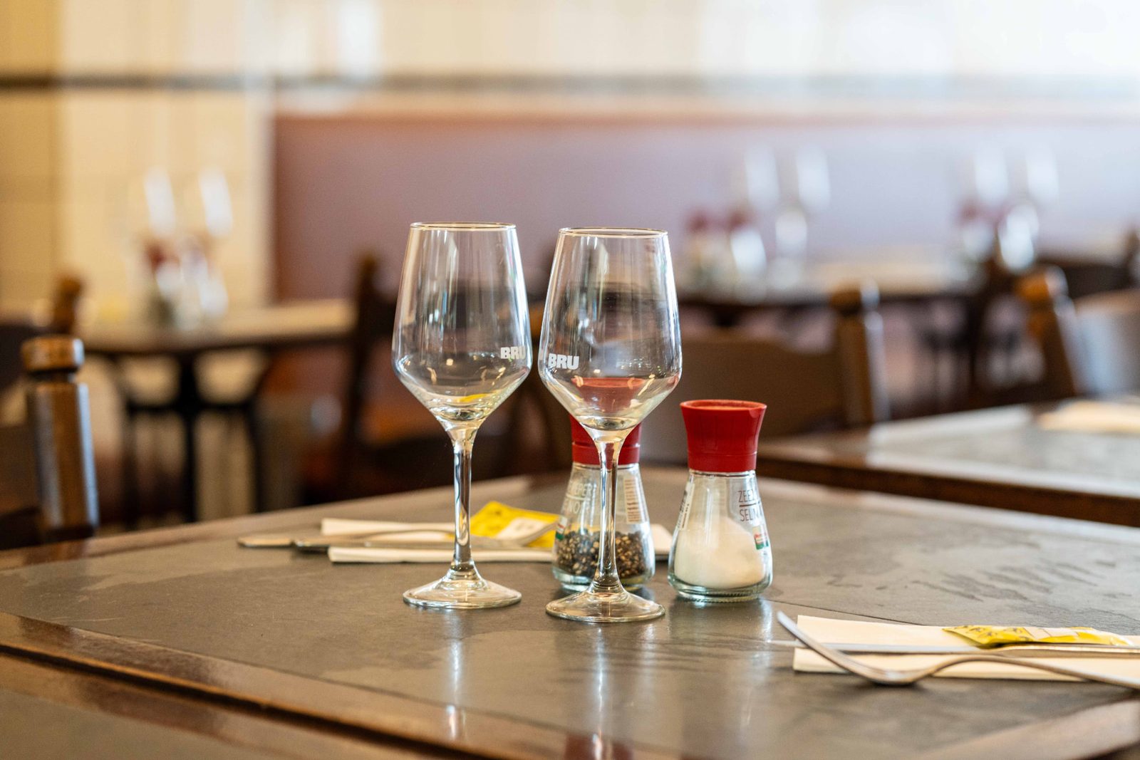 Deux verres BRU et les moulins sel et poivre sur une table du Pré Salé avant le service