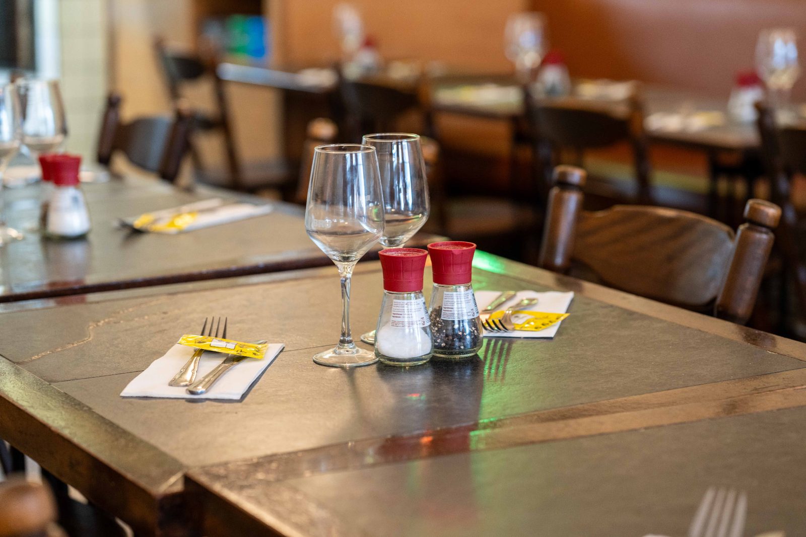 Table dressée du Pré Salé : verres à vin, sel et poivre, couverts sur le plateau en pierre