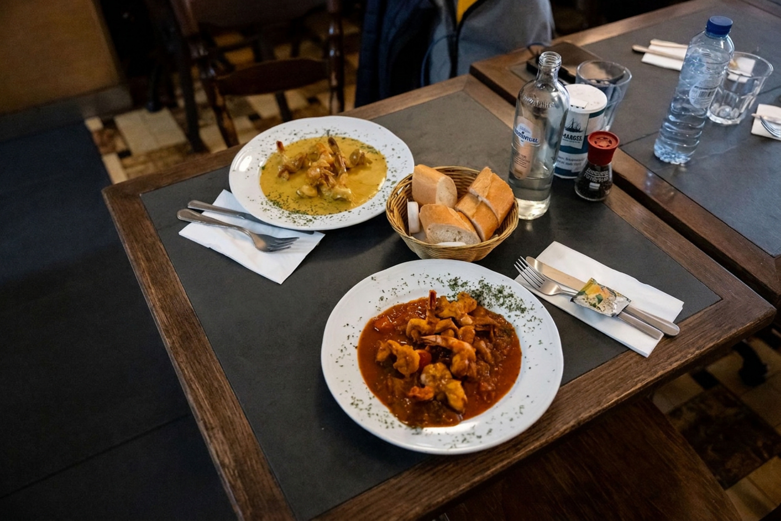 Gedekte tafel bij Le Pré Salé met twee Belgische gerechten, brood en water